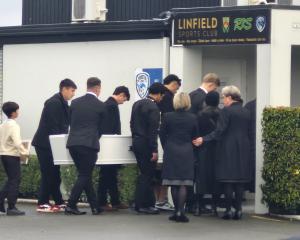 Mourners, including brother Jackson Garden-Bachop (rear left), carry the casket into the memorial...