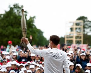 Nicolas-Marie Daru holds the Olympics torch in Colleville-sur-Mer, in Normandy, last month. Photo...