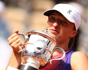 Iga Swiatek celebrates with the trophy after her victory in the French Open final. Photo: Reuters