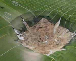 A drone view shows a sinkhole that formed on a turf football field. PHOTO: REUTERS 
