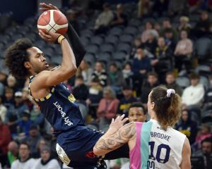 Kimani Lawrence jumps his shot for the Otago Nuggets under pressure from Whai player Denhym...