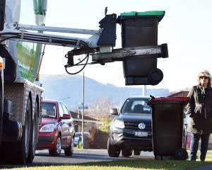 Mosgiel resident Katrina Clark watches the kerbside collection truck pick up the new green waste...