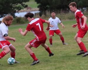 Balclutha AFC player Brennan Dinnissen prepares to nutmeg one of his Old Boys opponents in...