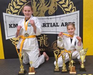 Megan, 12 (left), and Emerson, 9, Douglas show off their  championship trophies from the KMAC...