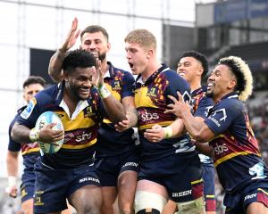 Highlanders winger Timoci Tavatavanawai is congratulated by team-mates (from left) Jacob...