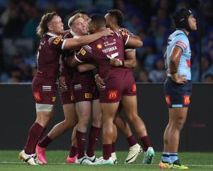 Queensland celebrate a try on a dismal night for Blues fans in Sydney. Photo: Getty Images