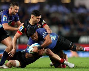 Akira Ioane of the Blues is tackled by Shaun Stevenson of the Chiefs during the Super Rugby...