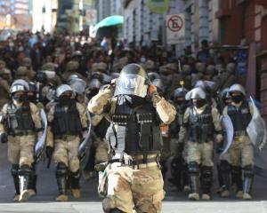 Military police make their way into the central square in Bolivia's capital La Paz as an...