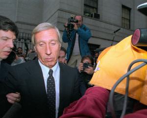 Members of the media surround corrupt financier Ivan Boesky and his attorney as they arrive at...