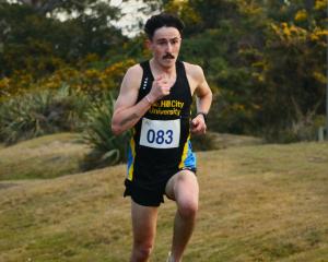 Hill City-University runner Oli Chignell runs over a mound on his way to winning the Edmond Cup...