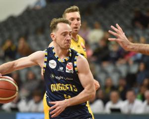 Otago Nuggets point guard Darcy Knox hustles up court, watched by Taranaki Airs player Mitch...