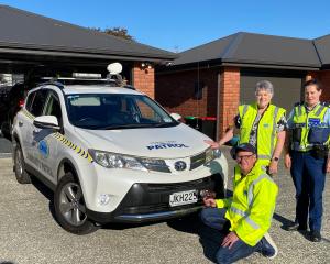 Mosgiel-Taieri Community Patrol member Chris Gouverneur secures a number plate while patrol...