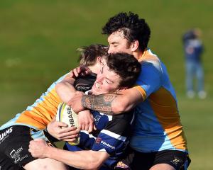 Kaikorai centre Troy Anstiss is swamped by University defenders Stanley McClure (left) and Thomas...