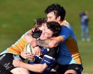 No. 11 Stanley McClure and No. 13 Thomas Umaga-Jensen for University of Otago wrap up No. 13 Troy...