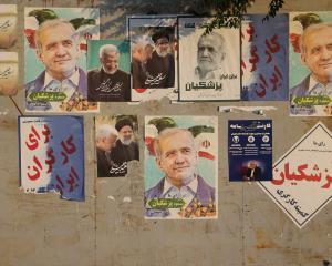 Posters of Iranian presidential candidates Masoud Pezeshkian and Saeed Jalili displayed in a...
