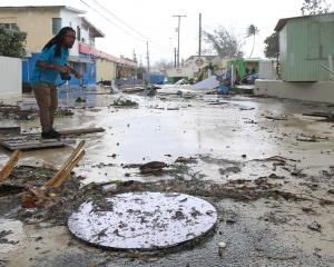 A man walks along a debris-filled street in the Hastings neighbourhood after Hurricane Beryl...