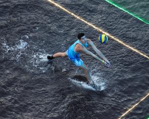 A man plays volleyball during an international "volleyball on water" tournament where teams...