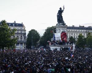 Supporters of the left wing alliance gather in Paris as a giant French flag is raised on the...