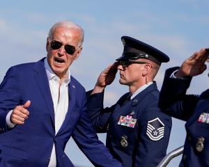 President Joe Biden gestures as he prepares to board Air Force One after attending a campaign...