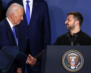 Ukraine's President Volodymyr Zelenskiy and US President Joe Biden shake hands at NATO's 75th...