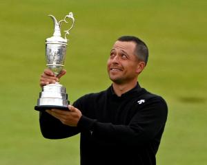 Xander Schauffele celebrates with the Claret Jug trophy after winning the 152nd Open Championship...