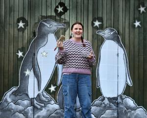 Dunedin artist Bee Lazarevic with her new hoiho artwork, one of many works by street artists to...