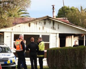 Police and fire officials work at the scene of a fatal house fire in Hoffman St, Hokitika. PHOTO:...