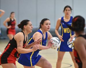 Dunedin wing attack Tia Pavihi (with ball) looks to pass against Christchurch Black in their...