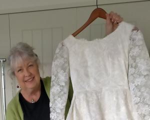 Ange Gibbs holds a wedding gown worn by Coralie Heads on her wedding day in 1965. PHOTO: SUPPLIED