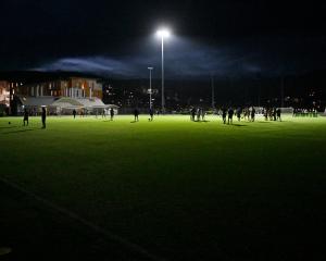 Otago University and Auckland City players stand in a pool of light after the lights at Logan...