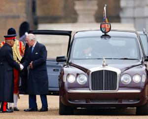 King Charles gets out of a Bentley limousine to greet Sir Kenneth Olisa, Lord-Lieutenant of...