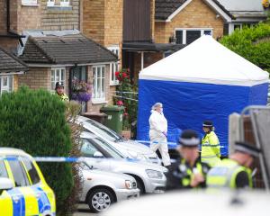 A police forensics tent outside a property in the town of Bushey where three people were killed....