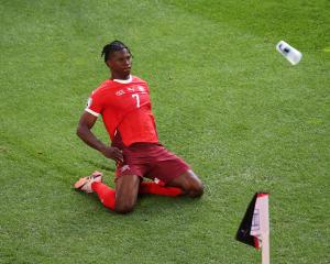Breel Embolo celebrates scoring Switzerland's first goal as a fan throws a plastic cup during...