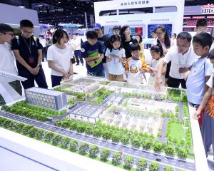 Visitors view a smart park model of State Grid Tianjin Electric Power at the 26th China Beijing...