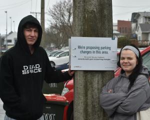 Harbour Tce residents Finlay Tomkins and Dana Wister next to a sign stating the proposed changes...