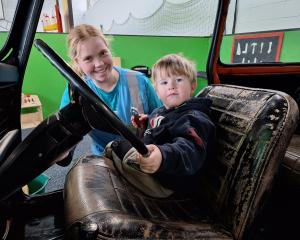 Jorga McKinley helps Blake McIlwrick, 3, sort the driving in Tiny Town at the Kidzone Festival....