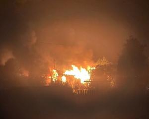 Flames engulf a View St house, in Manapouri, early yesterday. PHOTO: MIKE MOLINEUX