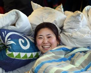 Bedding bank volunteer Wingkei Chen cozied up in the many blankets up for grabs at the Winter...