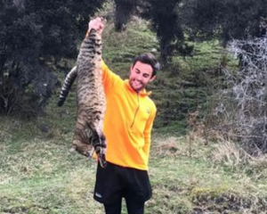Southern Lakes Sanctuary Trust biodiversity coordinator Greg Whall with a feral cat. Photo:...