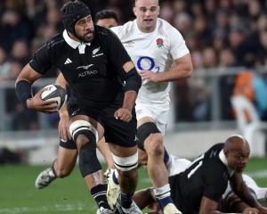 All Blacks lock Patrick Tuipulotu is pursued by England No8 Ben Earl as Mark Tele’a looks on...