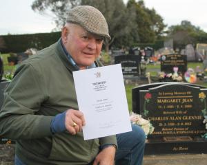 Alex Glennie holds his father’s certificate at his grave at Invercargill cemetery. PHOTO: LUISA...