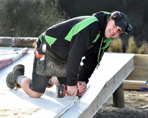 Dunedin builder Sacha Gray drills a hole on a building site. The cost to build a new house in New...