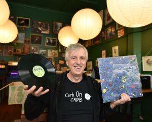 Avid record collector Scott Muir holds some of the items he had for sale at a records and Kiwiana...