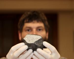 University of Otago geologist Dr Marshall Palmer shows the first meteorite believed to be found...