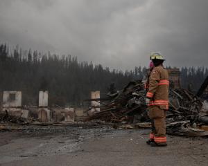 Fire crews work to put out hotspots at Maligne Lodge in Jasper, Alberta, Canada. PHOTO: REUTERS