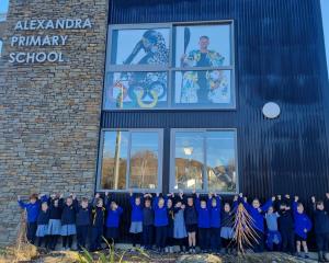 Alexandra Primary School pupils celebrate Finn Butcher's win in front of a window display of him...