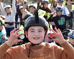 Big Rock School pupil Quaye Driver, 9, with his new bike lights in front of his peers yesterday....