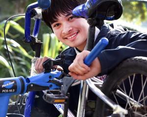 Trinity Catholic College student Cooper Pauley, 14, fixes a bike for children to ride at the...