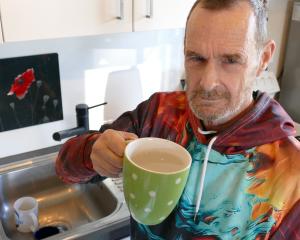 Milton resident Graham Button holds a mug of the tap water he believes may have caused a serious...