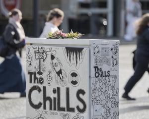 A floral posy placed on a traffic-control box featuring a tribute to Dunedin band The Chills in...